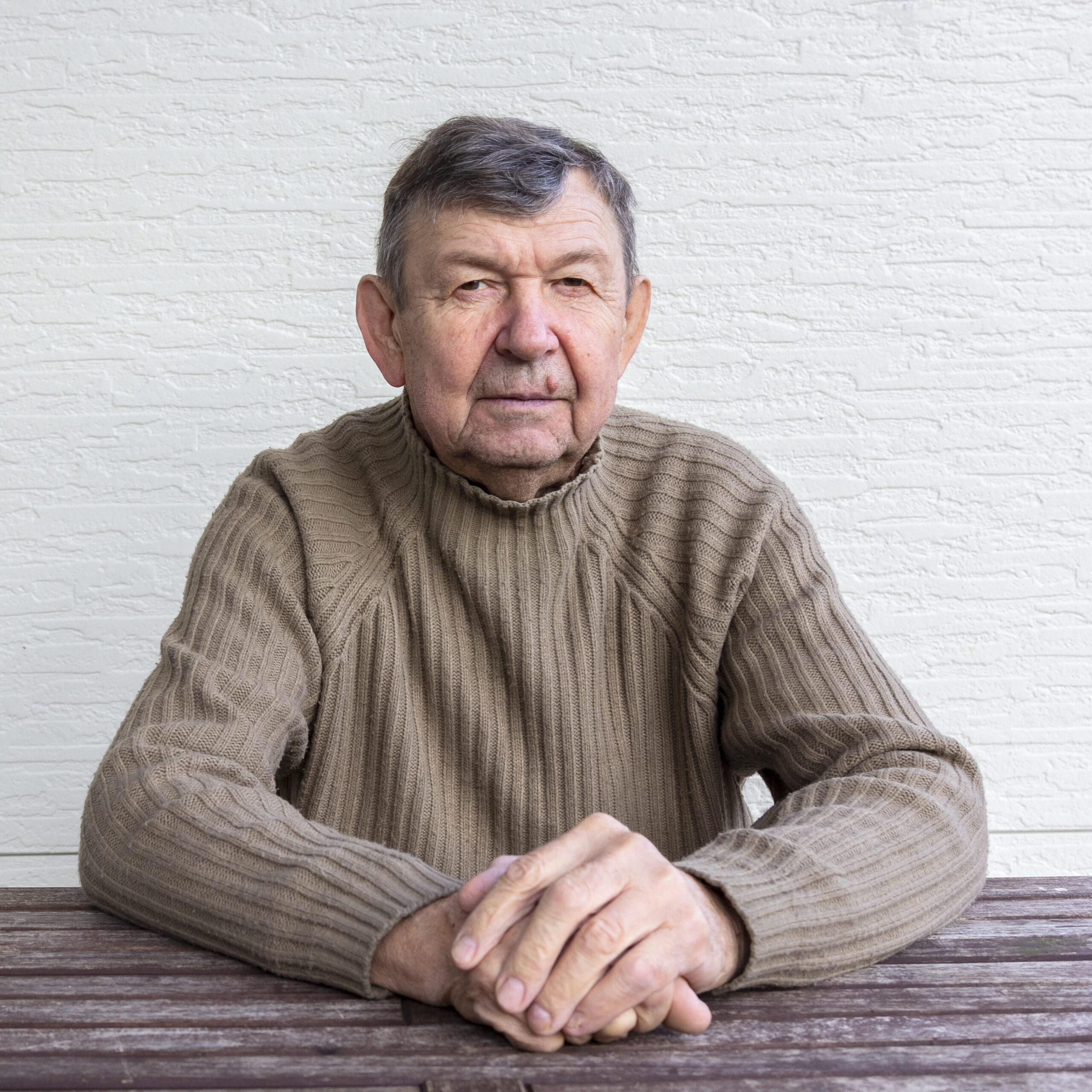 portret-stary-senior-krzyzowal-marszczace-reki-patrzeje-kamere (1)